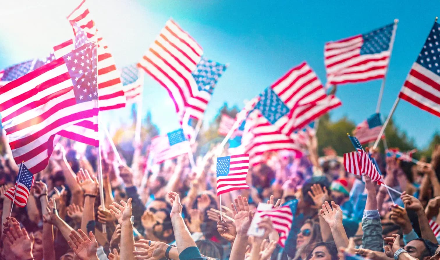 Crowd waving American flags at a rally